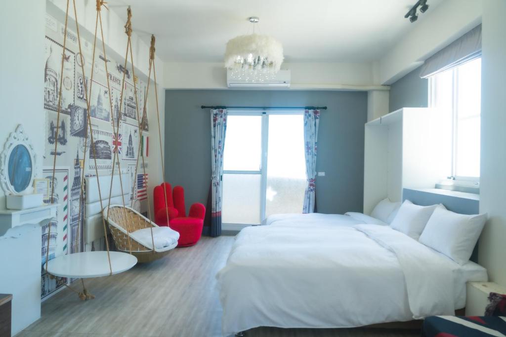 a bedroom with a large white bed and red chairs at Love Green in Green Island