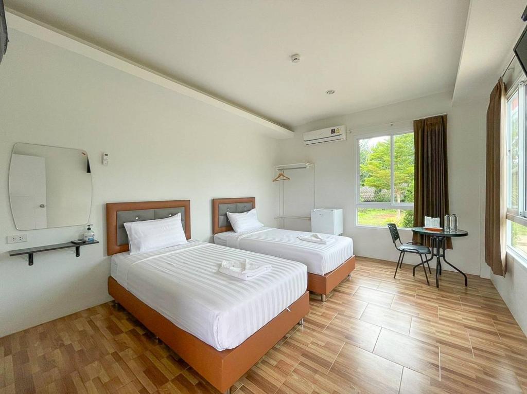 een hotelkamer met 2 bedden en een televisie bij My Heaven Resort in Trang