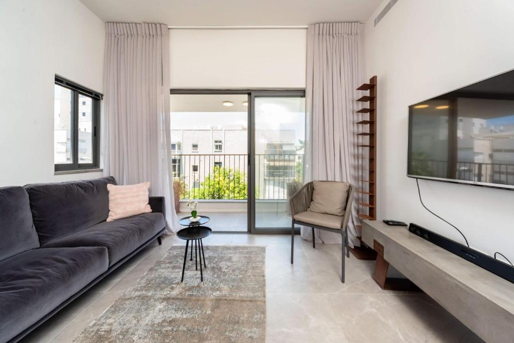 a living room with a couch and a flat screen tv at Luxurious Holiday Home, Arlozorov 8 in Tel Aviv