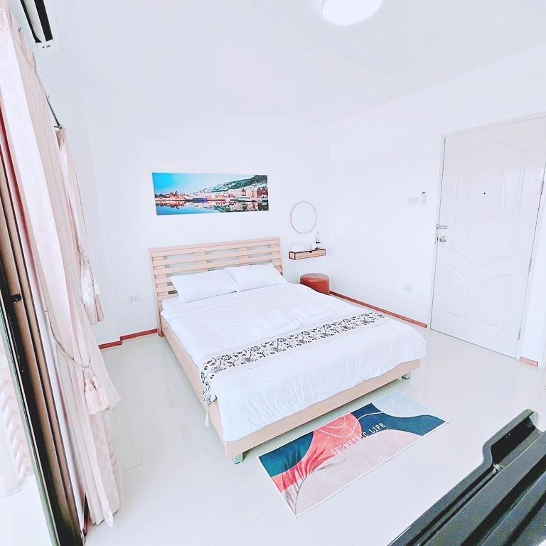 a white room with two beds and a window at Sugar Beach Bangsaen in Ban Bang Saen (1)