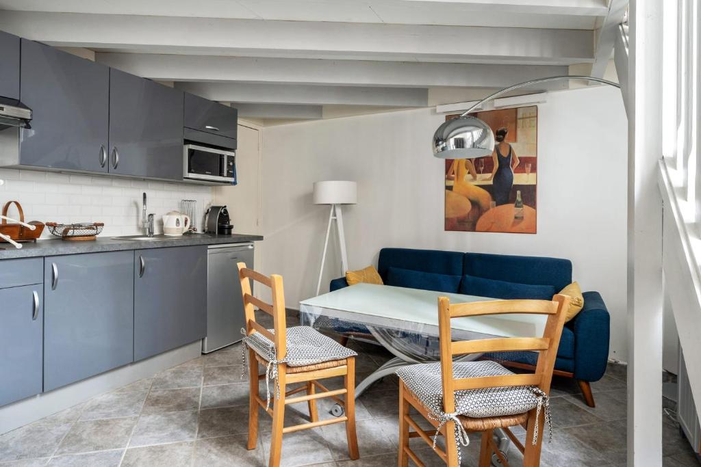 Charming duplex near Paris - Welkeys في بولون بيانكور: مطبخ وغرفة طعام مع طاولة وكراسي