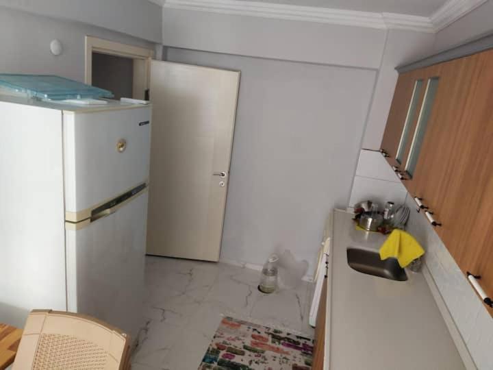 uma cozinha com um frigorífico branco e um lavatório em Luwigayrimenkul em Gokceada Town