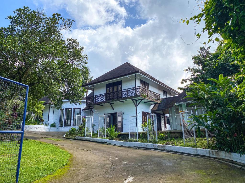 ein weißes Haus mit Balkon auf einer Straße in der Unterkunft Kavanah Suites Guinhawa Tagaytay in Tagaytay