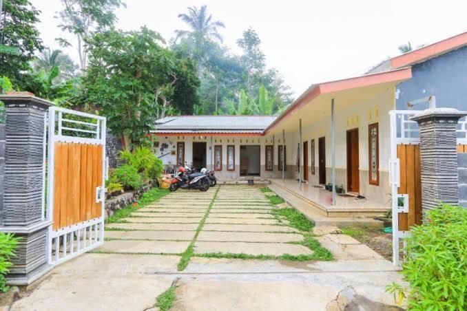 un groupe de maisons avec une moto garée à côté d'elles dans l'établissement Bali Ciliek Homestay, à Senduro