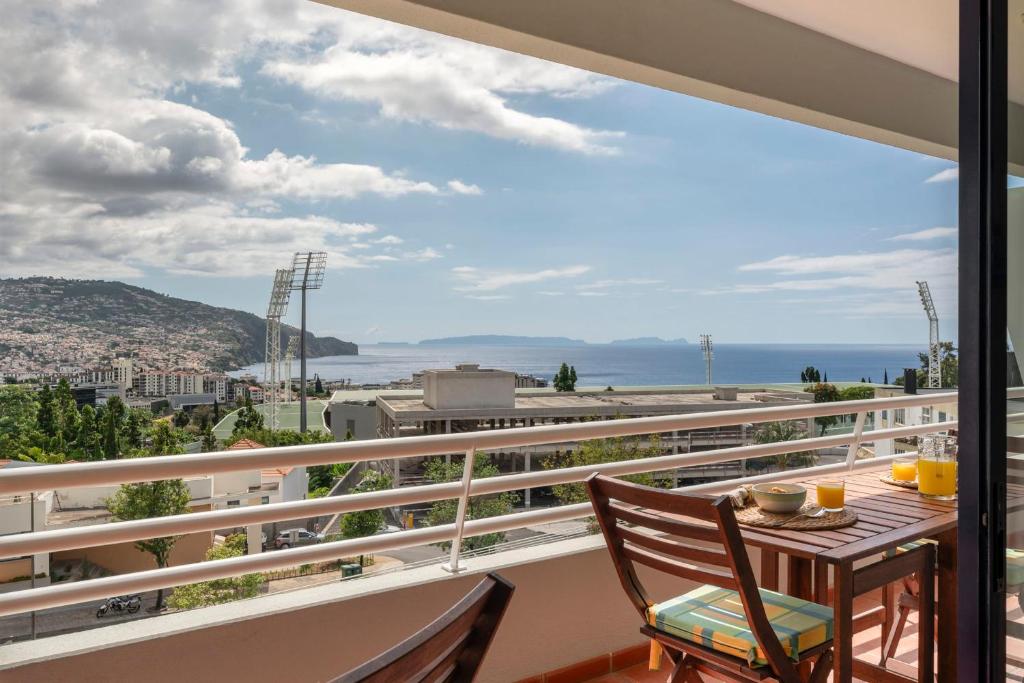 a balcony with a table and chairs and a view of the ocean at Funchal bay view Vista Mar I in Funchal
