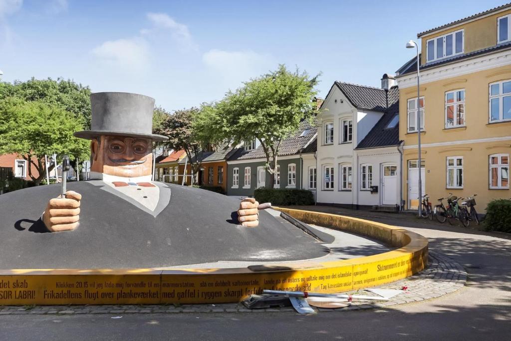 una pintura de un hombre con sombrero de copa en un cartel en Professor Labri Apartments en Odense