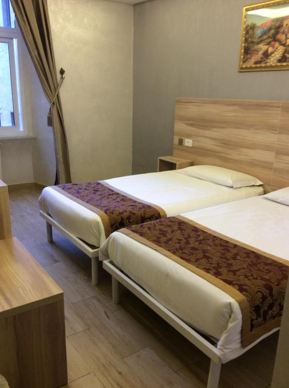 a hotel room with two beds and a window at Hotel Rome Love- close to Roma Termini in Rome