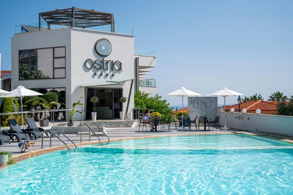 a hotel swimming pool in front of a building at Ostria Sea Side Hotel in Hanioti