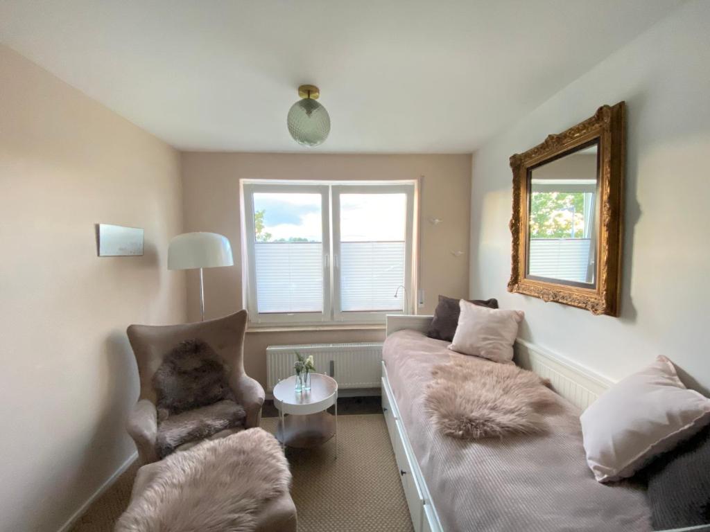 a living room with a couch and a mirror at Ferienwohnung Lieblingsplatz in Aichtal-Grötzingen in Aichtal 