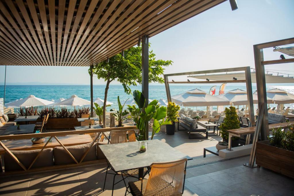 un patio con mesa, sillas y el océano en Ostria Sea Side Hotel en Hanioti