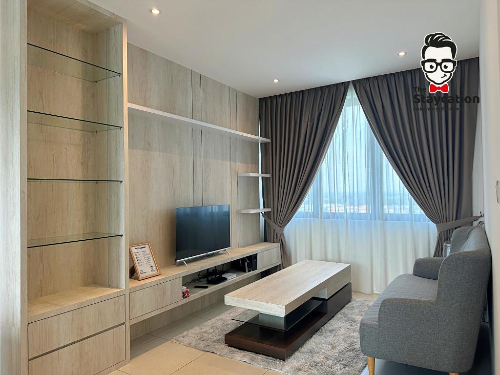 sala de estar con TV y silla en Staycation Homestay 24 Royal Richmond Near Airport en Kuching