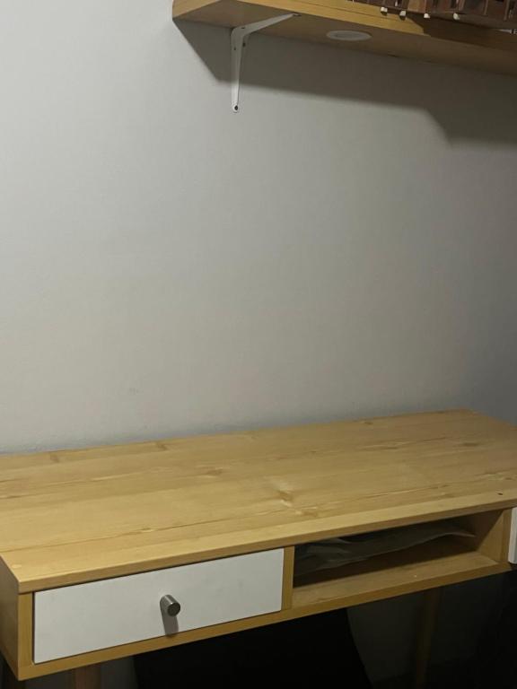 un escritorio de madera contra una pared blanca con un cajón en Alójate en una Casa familiar, en Barranca