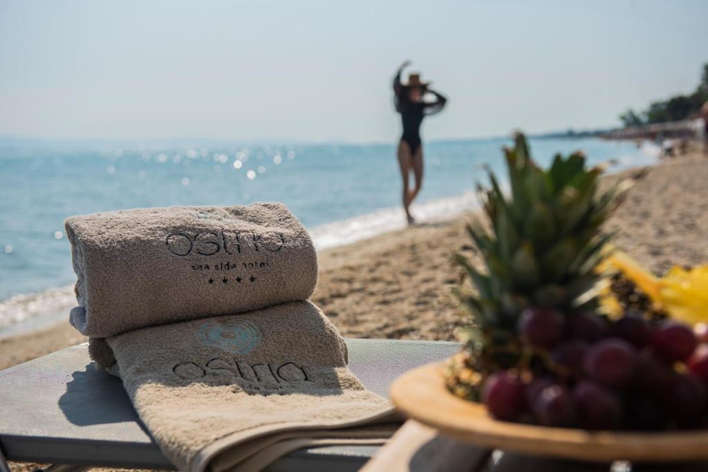 a pile of towels sitting on a table at the beach at Ostria Sea Side Hotel in Hanioti