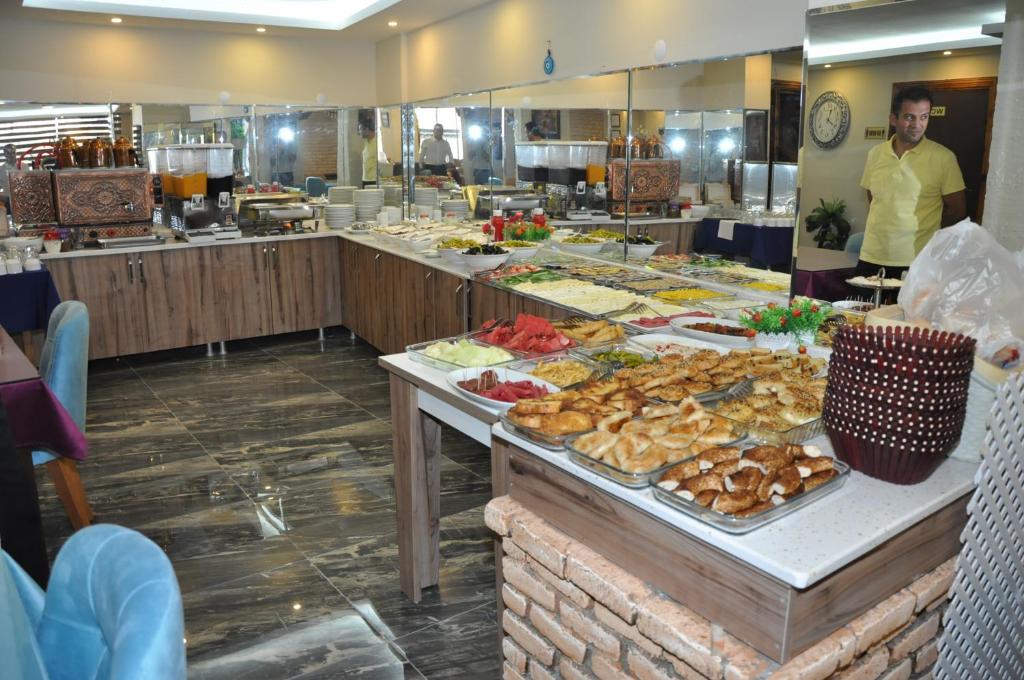 una línea de buffet con muchos tipos diferentes de comida en Konak EuroBest Otel en Konak