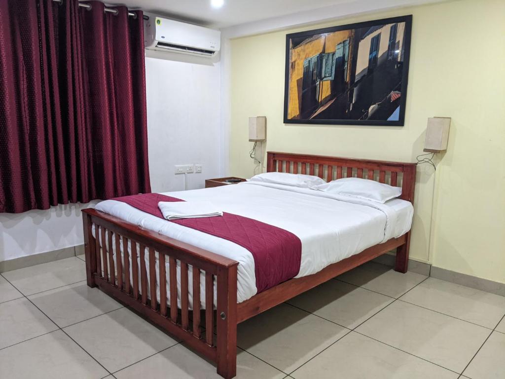 a bedroom with a bed and a painting on the wall at Green View Executive Stay's in Ernakulam