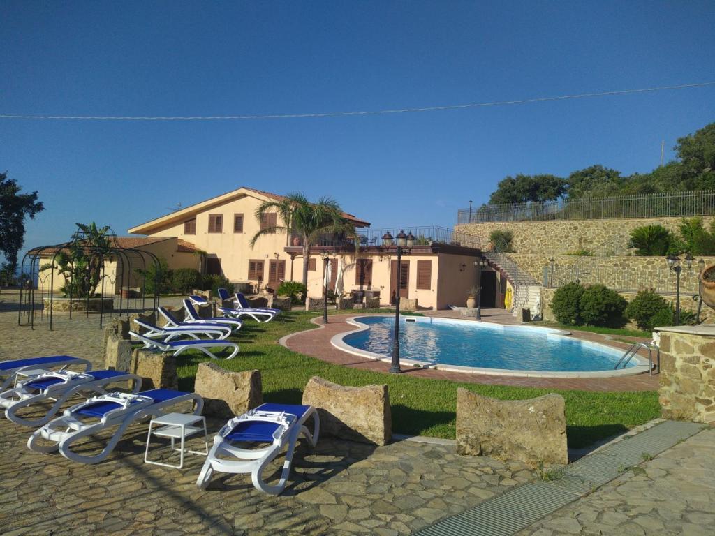 a group of lawn chairs and a swimming pool at Case Magliolo in Cefalù