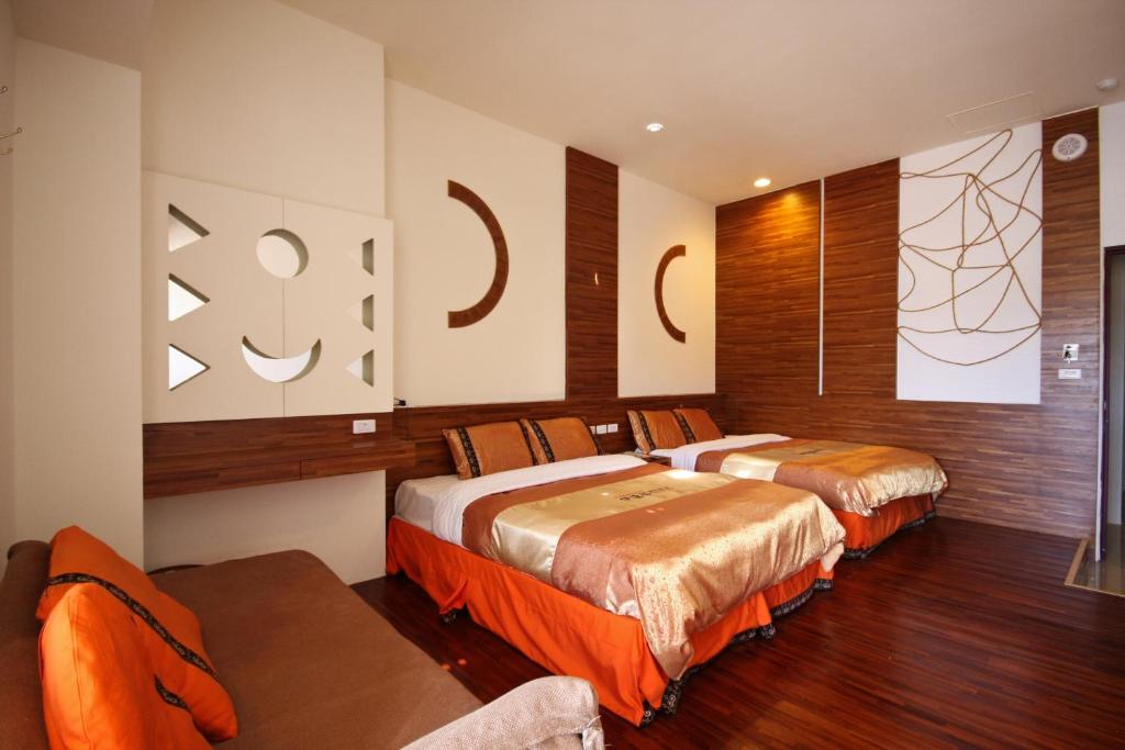 two beds in a room with wooden floors at Itathao Vacation Hotel in Yuchi