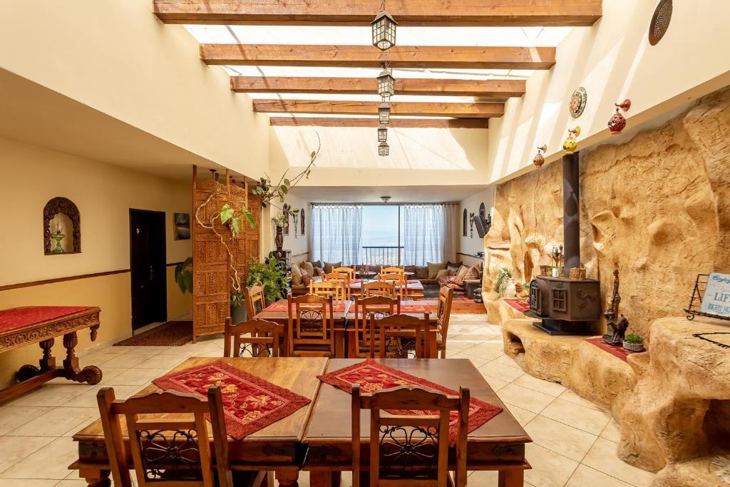 a restaurant with tables and chairs and a fireplace at Elmanzool Carmel Lodging in ‘Isfiyā