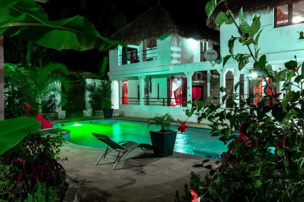 a pool in front of a house at night at VILLA AMNESYA NOSY BE in Nosy Be