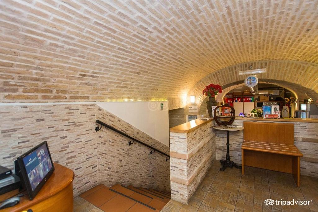 een kamer met een bakstenen muur en een aanrecht met een tv bij Hotel Il Papavero in Rome