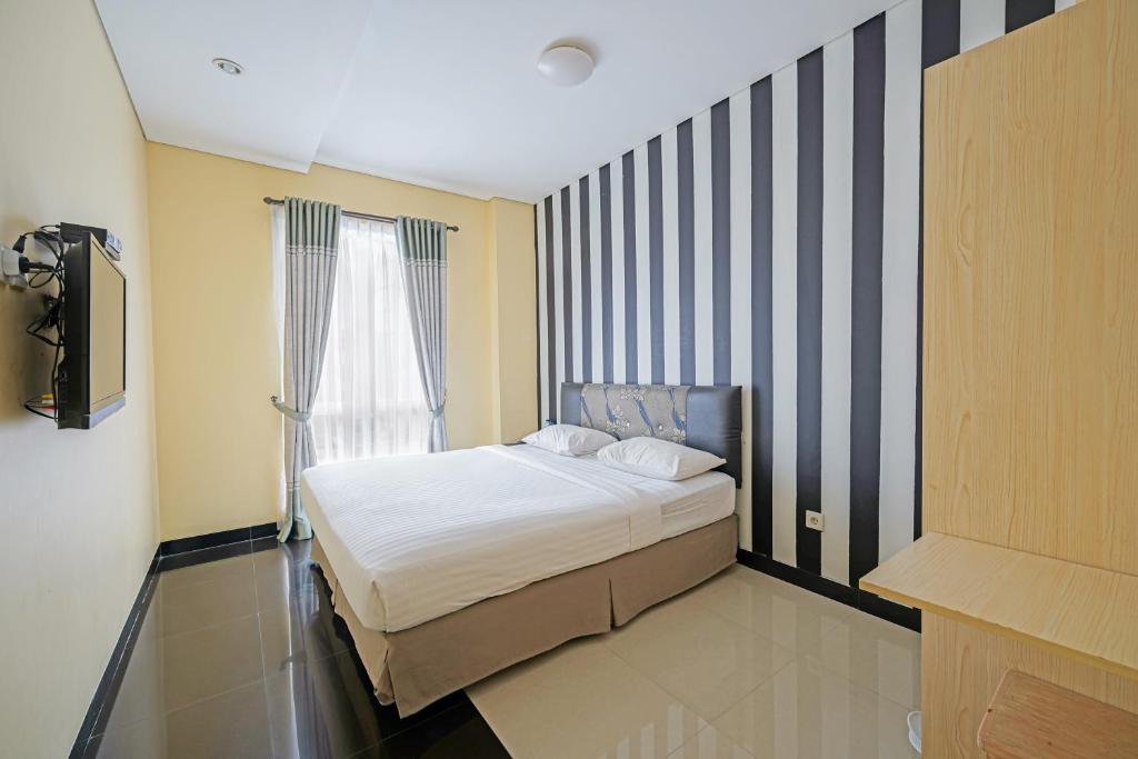 una piccola camera da letto con un letto e una finestra di Multi 88 Syariah a Giacarta