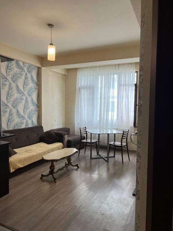 uma sala de estar com um sofá e uma mesa em Квартира в Диди Дигоми, Автандили N7 em Tbilisi