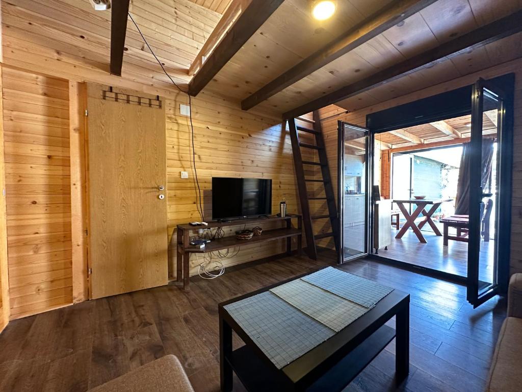 uma sala de estar com televisão e uma mesa num quarto em Tiny House Ada Bojana em Ulcinj