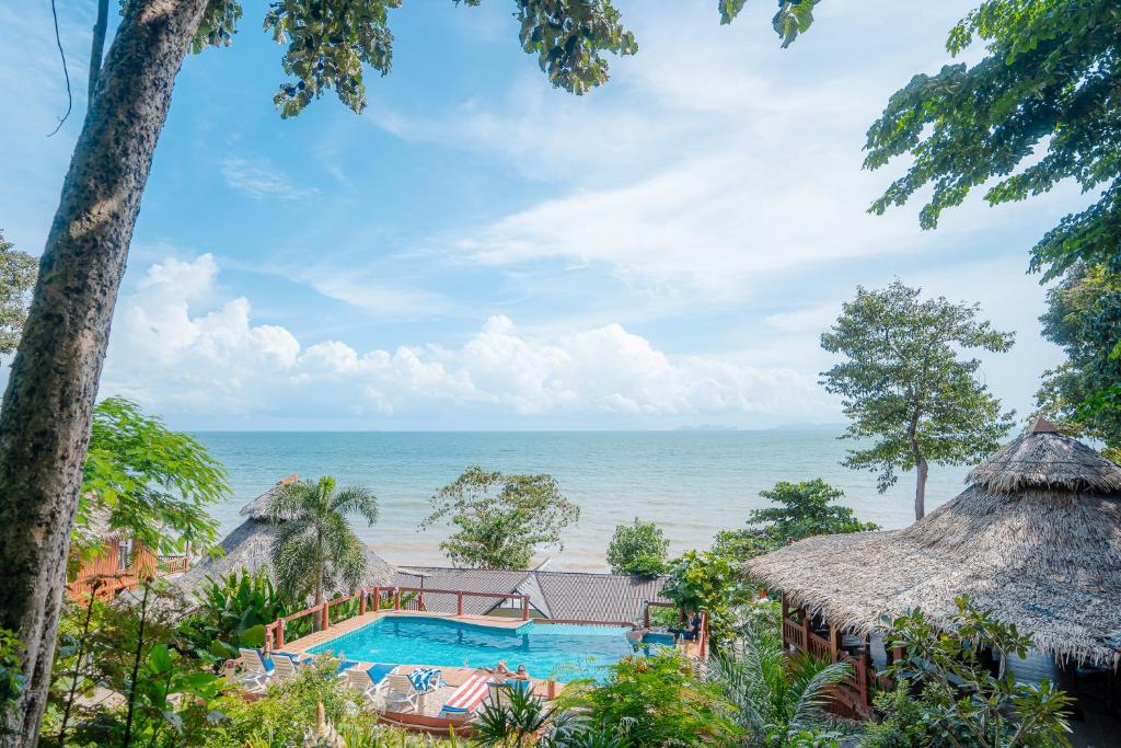 a resort with a swimming pool next to the ocean at Koh Jum Resort in Ko Jum