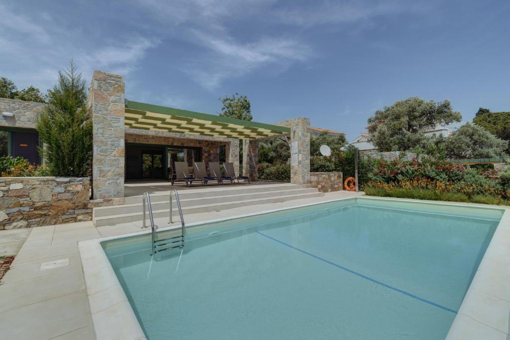 una piscina frente a una casa en Ouzo Stone House 1 with private pool, en Plomari
