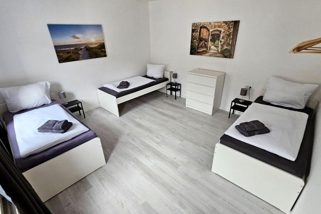 una habitación con dos camas y una mesa y sillas en Apartments in Nienburg (Saale), en Grimschleben