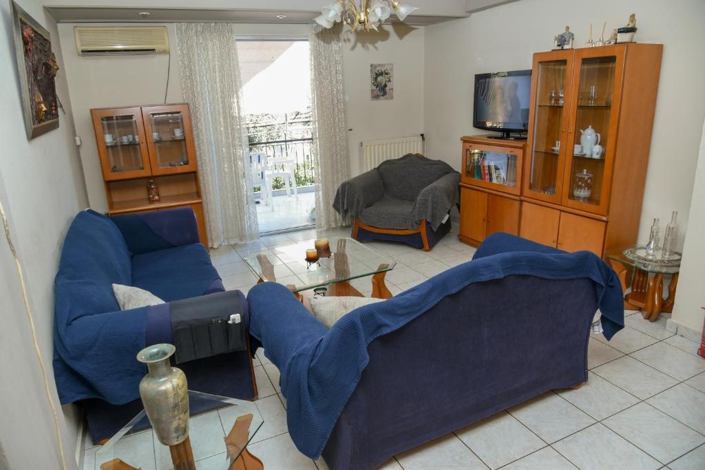 sala de estar con 2 sillas azules y TV en ΣΠΙΤΙ ΜΕ ΚΗΠΟ en Atenas