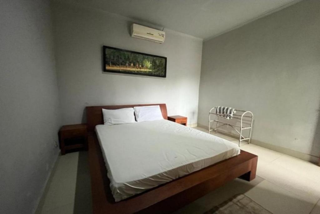 una camera da letto con un grande letto con lenzuola bianche di OYO 92909 Penginapan Sarinah Syariah 