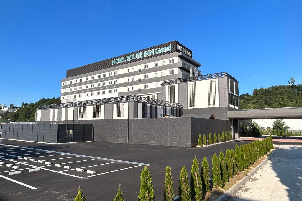 a building with a parking lot in front of it at Hotel Route Inn Grand Chichibu in Chichibu