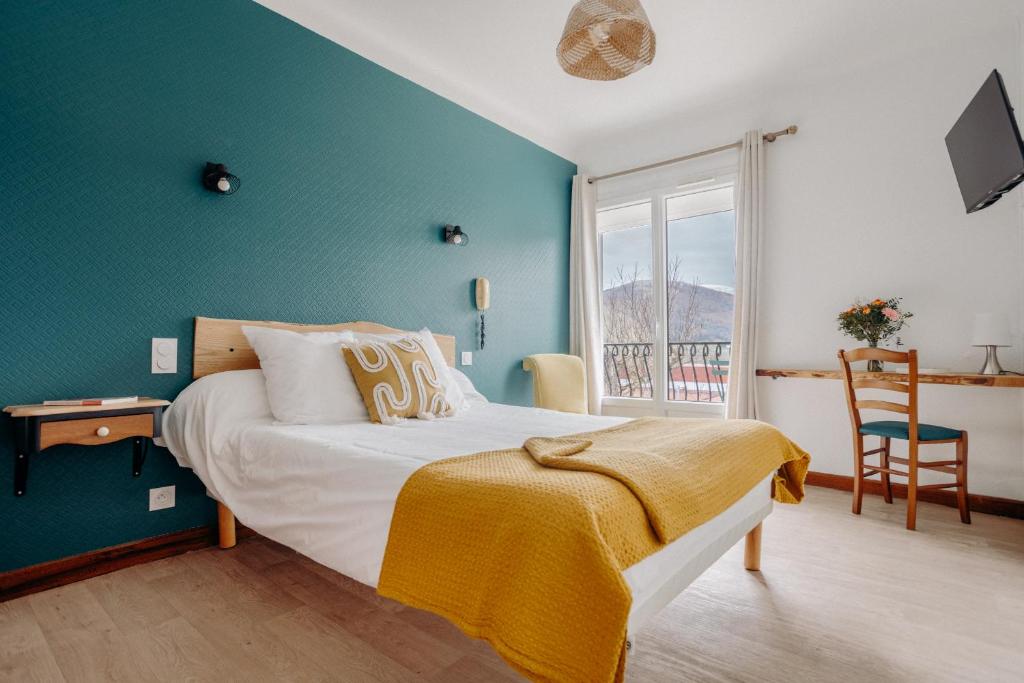 a bedroom with a bed with a blue wall at Logis Hôtel Restaurant Espelletenia in Larceveau-Arros-Cibits