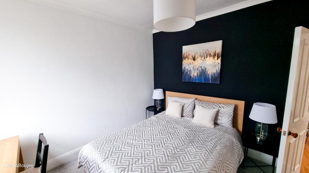 a bedroom with a bed and a black wall at Central Exeter's Perfect 2 BR Flat in Exeter