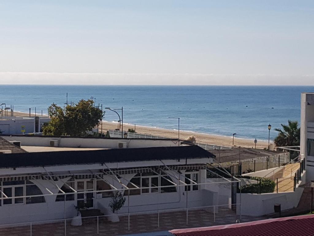 a building on the beach with the ocean in the background at Apartamento 335 Hotel Flamero in Matalascañas