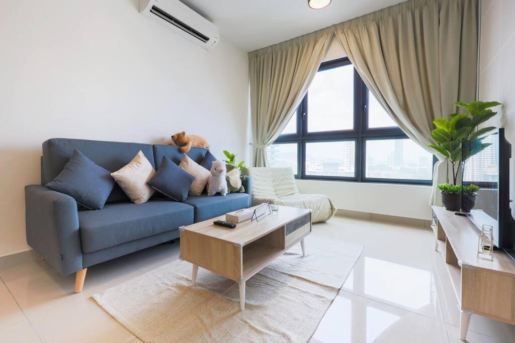 sala de estar con sofá azul y mesa en M Vertica KL Residence, en Kuala Lumpur