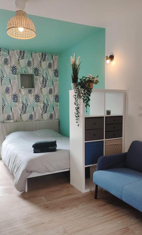 a bedroom with a bed and a blue wall at Studio calme et discret in Brest