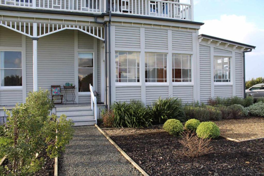 ein weißes Haus mit Balkon darüber in der Unterkunft The Suite - Huntly House in Auckland