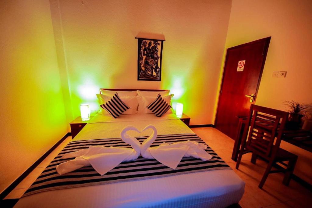 a bedroom with a bed with two heart shaped towels at Villa tadini in Galle