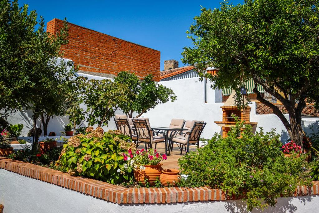 un patio con mesa, sillas y plantas en El Patio de los Naranjos, en Guadalupe
