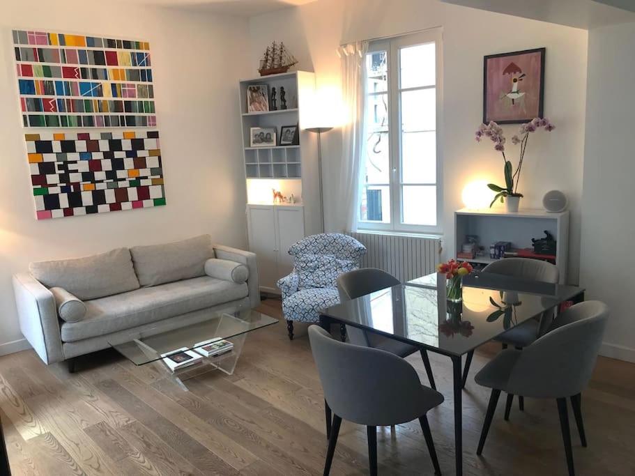 un salon avec un canapé, une table et des chaises dans l'établissement Superbe maison individuelle dans Paris, à Paris