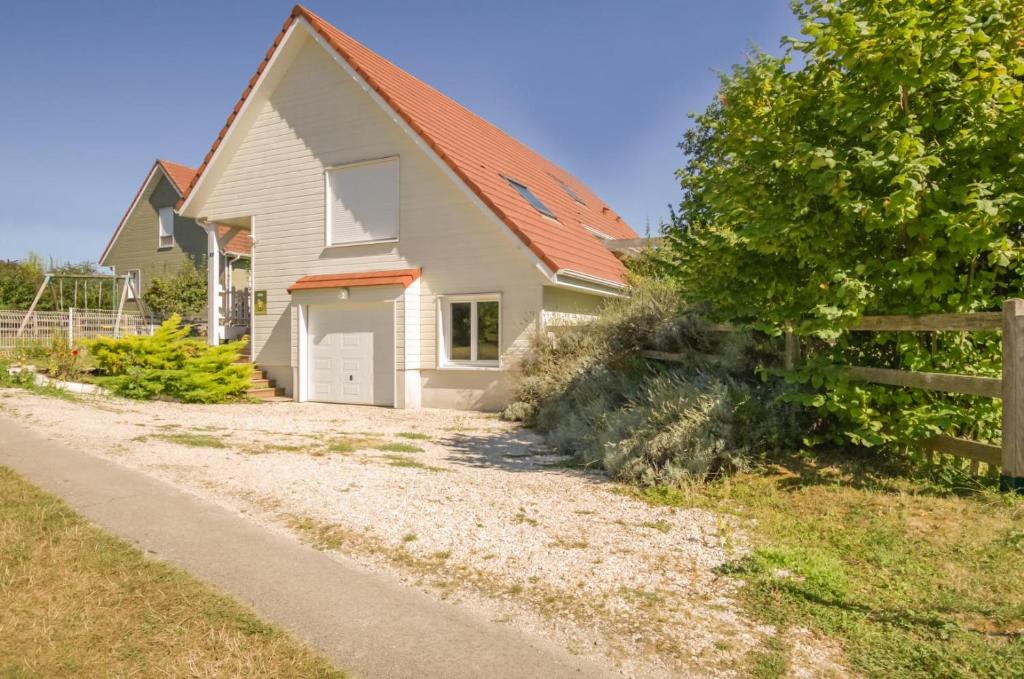 una casa blanca con techo naranja y valla en La rose des champs, en Ramerupt