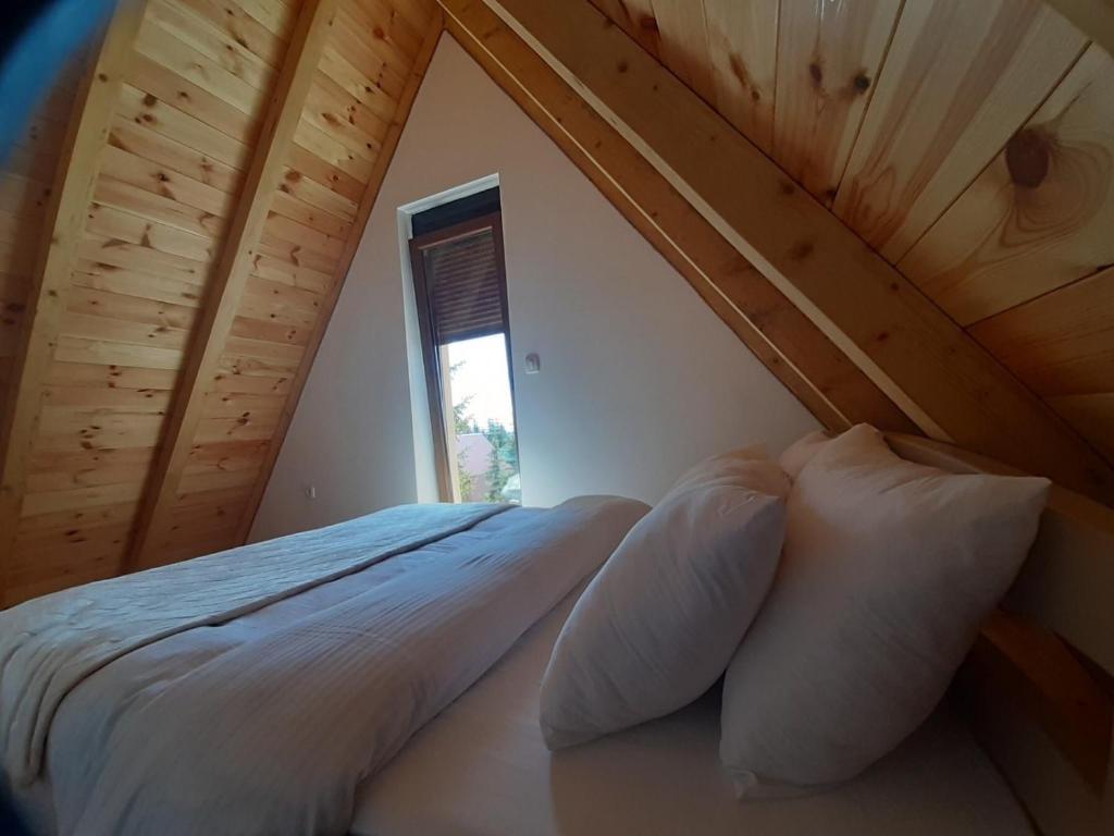 a bed sitting in a room with a window at Žabljak- FamilyOasis in Žabljak