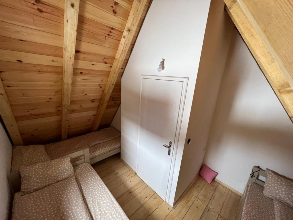 an attic room with a couch and a door at Žabljak- FamilyOasis in Žabljak