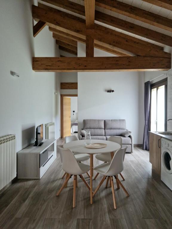 ein Wohnzimmer mit Tisch und Stühlen und einer Couch in der Unterkunft Apartamentos Villa de Panes - La Plaza in Panes