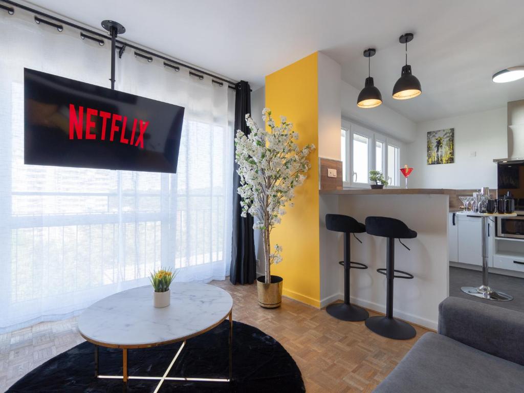 un salon avec une table et une cuisine dans l'établissement LE CELESTE - HYPERCENTRE PARKING ET NETFLIX GRATUITS PROCHE TRAMWAY ET PARC DE LA TETE D'OR, à Villeurbanne