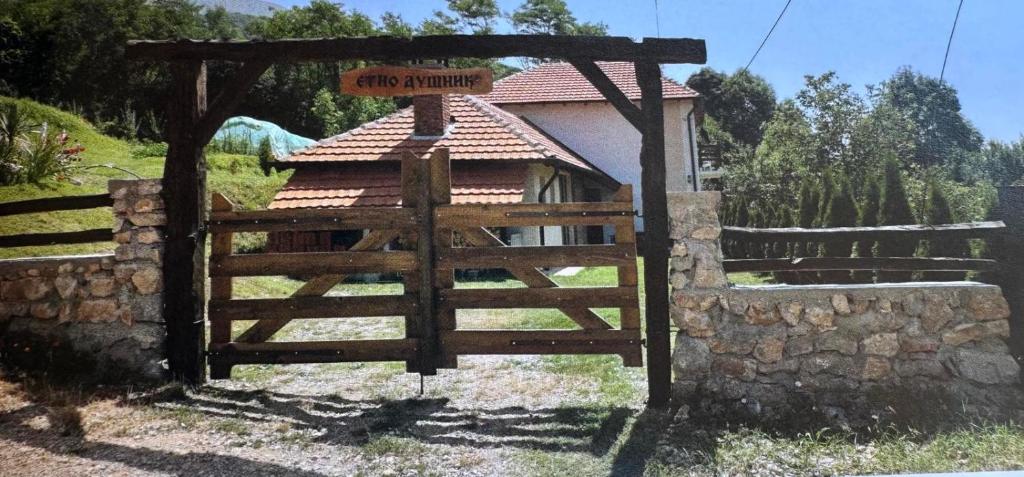 a wooden gate in front of a building with a fence at Etno Dušnik 
