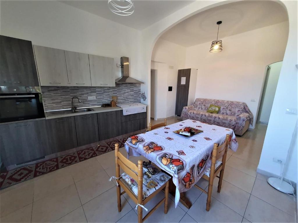 a kitchen with a table and a couch in a room at Villa Cecita Holiday in Sellia Marina