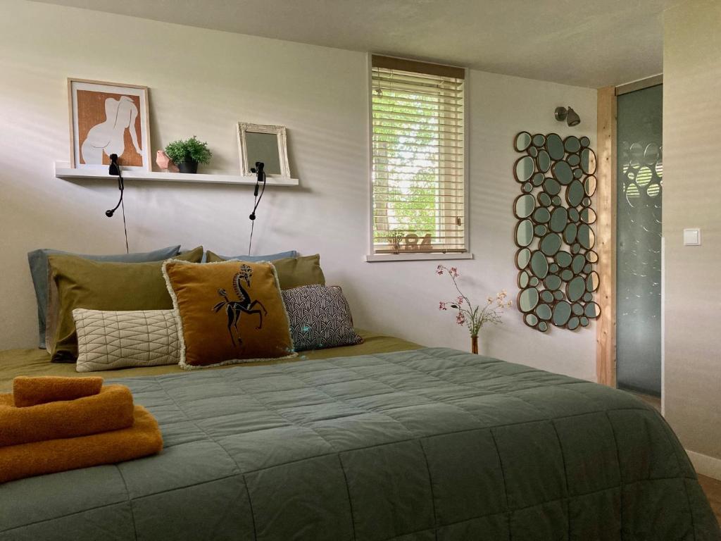 a bedroom with a large green bed with pillows at 84huis in Amstelveen